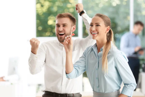 Jóvenes empleados felices con dardos en la oficina — Foto de Stock