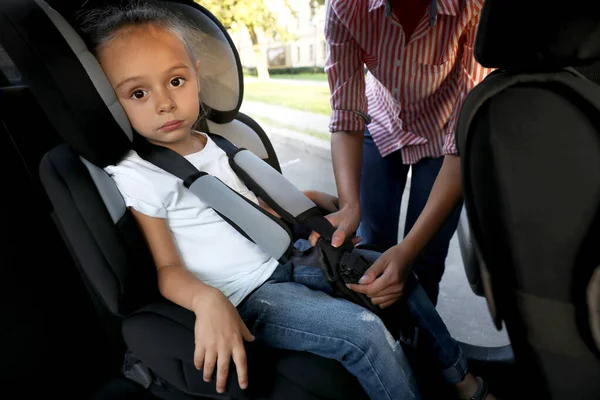 Mor spänner fast sin dotter med bilbälte. Familj semester — Stockfoto