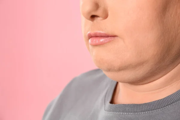 Woman with double chin on pink background, closeup. Space for text