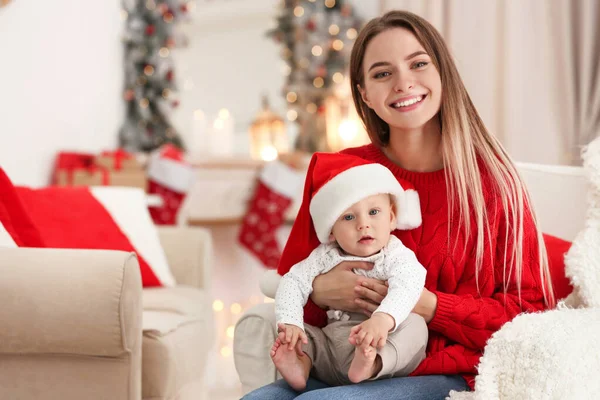 Madre feliz con lindo bebé en la habitación decorada para las vacaciones de Navidad —  Fotos de Stock