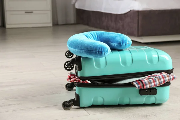 Koffer mit Kleidung und Reisekissen im Schlafzimmer — Stockfoto