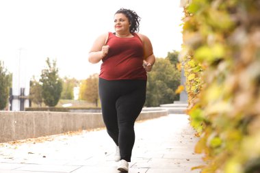 Parkta koşan güzel şişman kadın. Fitness yaşam tarzı
