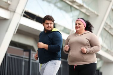 Açık havada birlikte koşan şişman bir çift. Fitness yaşam tarzı