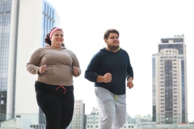 Açık havada birlikte koşan şişman bir çift. Fitness yaşam tarzı