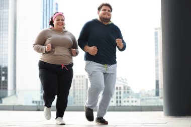 Açık havada birlikte koşan şişman bir çift. Fitness yaşam tarzı