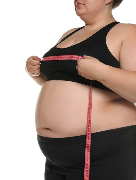 Mulher com excesso de peso medindo seu peito com fita adesiva em fundo branco, close-up — Fotografia de Stock