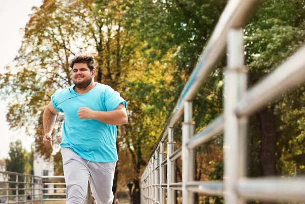Un giovane sovrappeso che corre all'aperto. Stile di vita fitness — Foto Stock