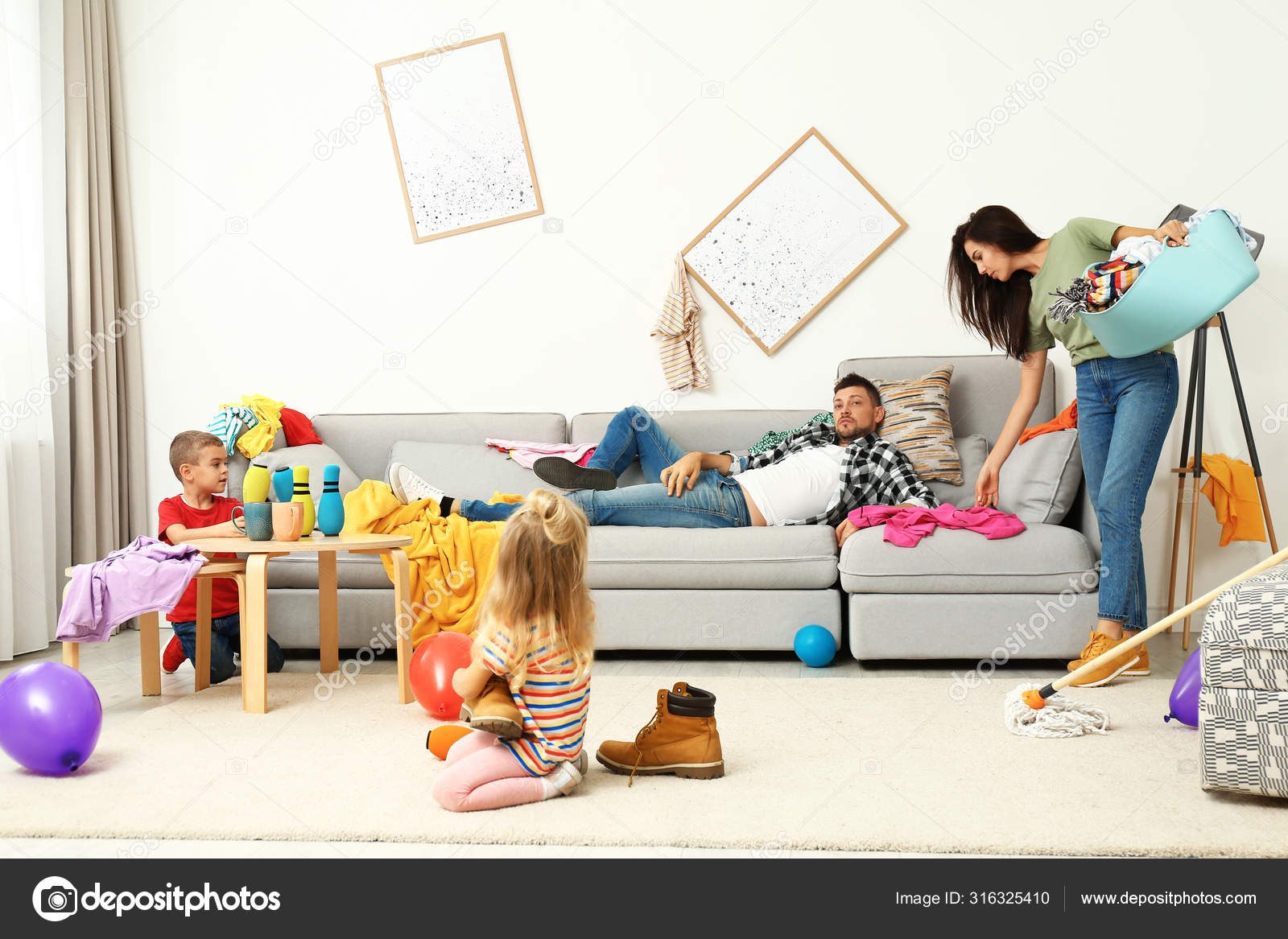 Exhausted mother trying to clean up mess made by children and lazy