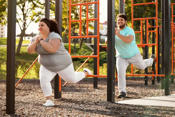 Sobrepeso pareja entrenamiento juntos en campo de deportes — Foto de Stock