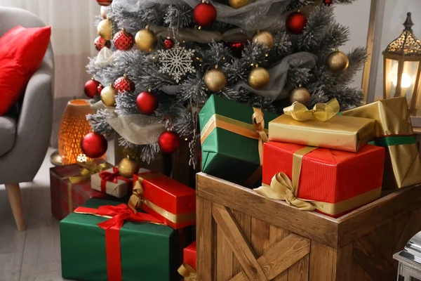 Fa láda ajándékdobozokkal és karácsonyfával az ünnepi terem belsejében — Stock Fotó