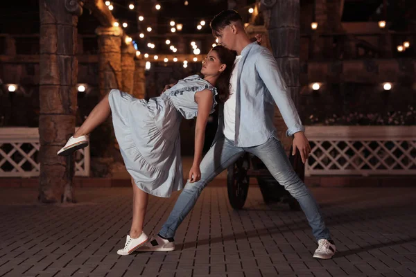 Hermosa pareja joven practicando movimientos de baile en la noche al aire libre — Foto de Stock