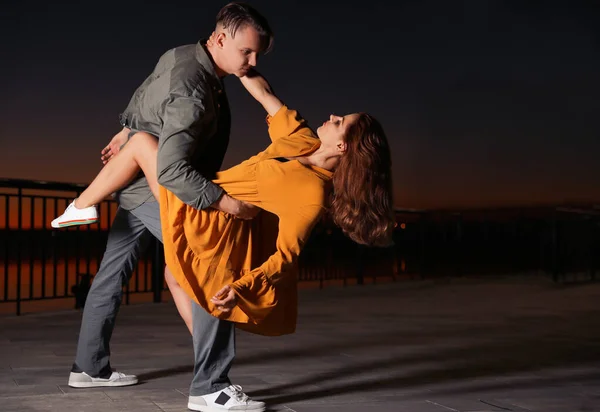 Hermosa pareja joven practicando movimientos de baile en la noche al aire libre — Foto de Stock