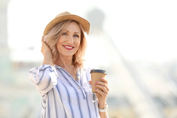 Beautiful mature woman with cup of coffee outdoors — Stock Photo, Image