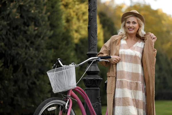Зрелая женщина с велосипедом на открытом воздухе. Активный образ жизни — стоковое фото