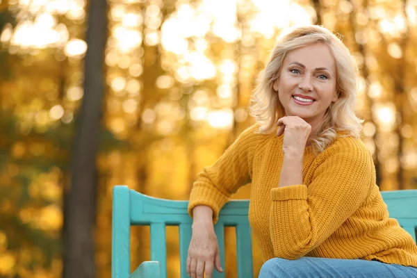 Retrato de mujer madura feliz en el banco en el parque — Foto de Stock