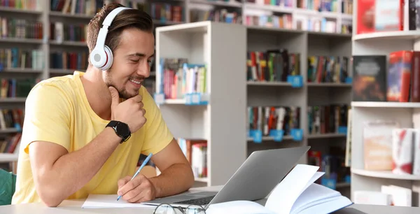 Jovem Estudante Usando Fones Ouvido Mesa Biblioteca Moderna Espaço Para — Fotografia de Stock