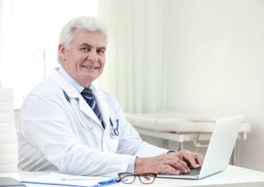 İş yerinde beyaz önlüklü kıdemli doktorun portresi.