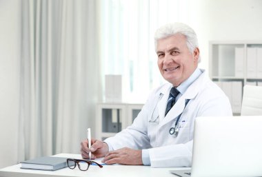 İş yerinde beyaz önlüklü kıdemli doktorun portresi.
