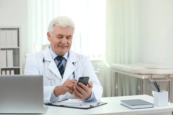 Médico Sênior Com Smartphone Mesa Escritório — Fotografia de Stock