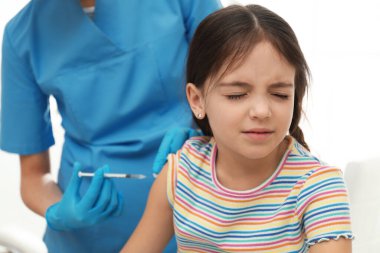 Modern klinikte küçük bir çocuğu aşılayan doktor.