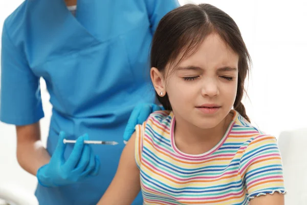 Modern klinikte küçük bir çocuğu aşılayan doktor.