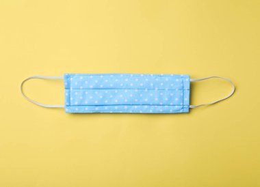 Sarı arka planda ev yapımı koruyucu maske. Dikiş fikri