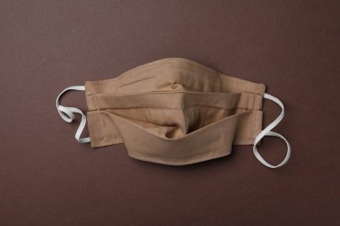 Kahverengi arka planda ev yapımı koruyucu maske. Dikiş fikri