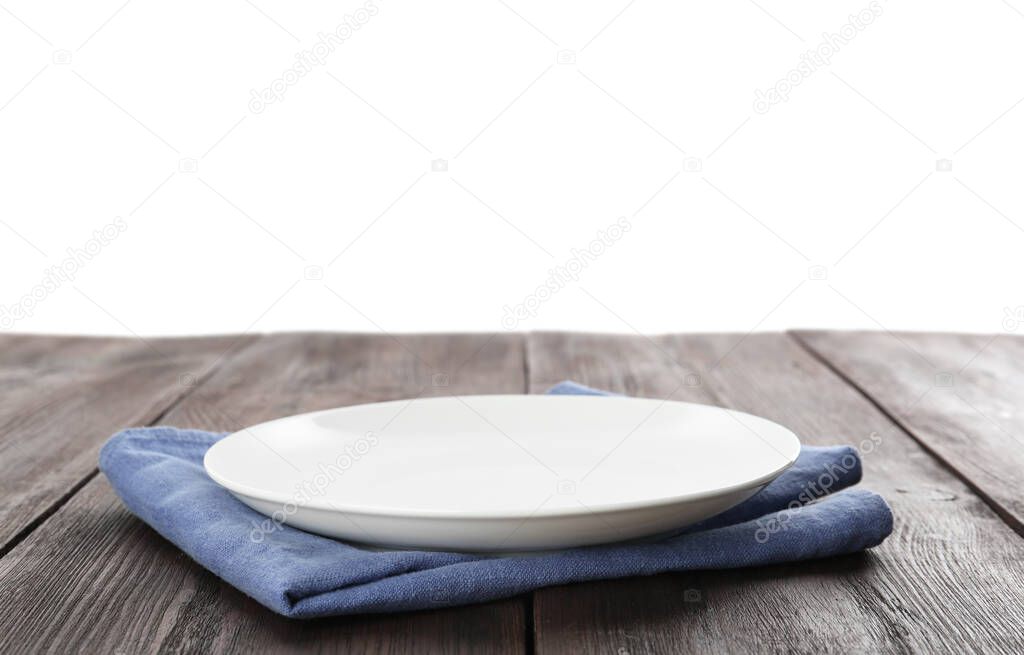 Empty plate and napkin on wooden table against white background