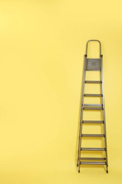 Sarı arka planda metal merdiven. Metin için boşluk