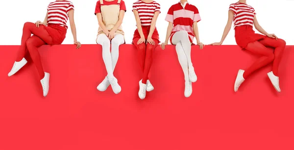Женщины Различных Ярких Колготках Стильной Обуви Сидя Цветном Фоне Крупным — стоковое фото