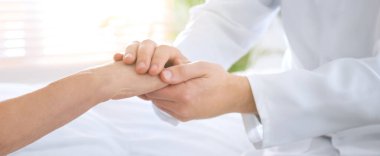 Doktor ve kıdemli hasta hastanede el ele tutuşuyor, yakın plan. Pankart tasarımı