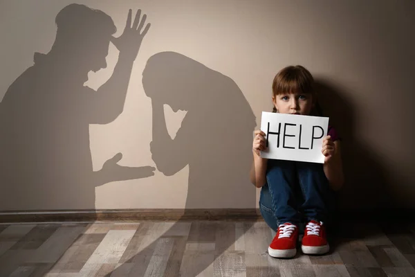 Menina Triste Com Sinal Ajuda Sentado Chão Silhuetas Pais Discutindo — Fotografia de Stock