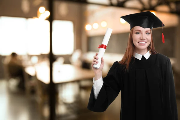 Happy student with graduation hat and diploma in office, space for text