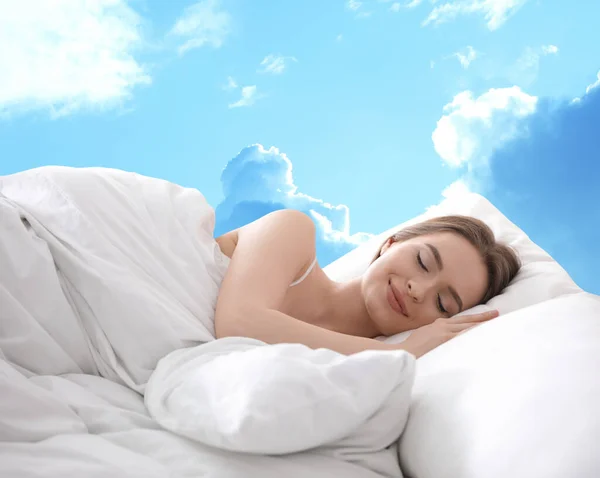 Young woman sleeping in bed. Blue sky on background