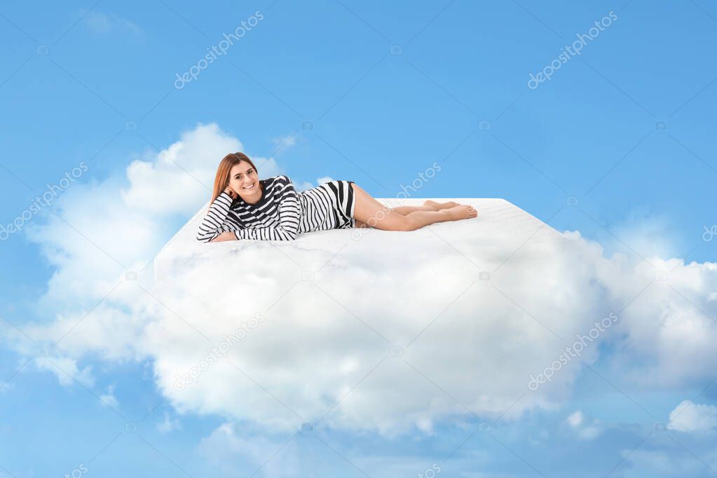 Beautiful woman lying on mattress in clouds