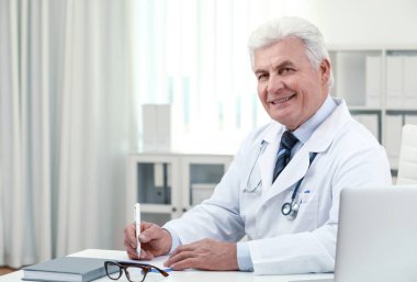 İş yerinde beyaz önlüklü kıdemli doktorun portresi.