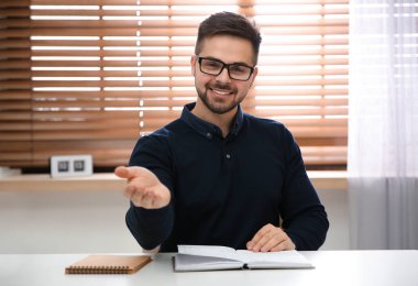 Modern ofiste görüntülü konuşma yapan mutlu adam, web kamerasından görüş