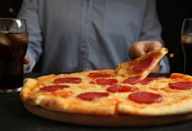 Lezzetli biberli pizzayı masaya götüren kadın, yakın plan.