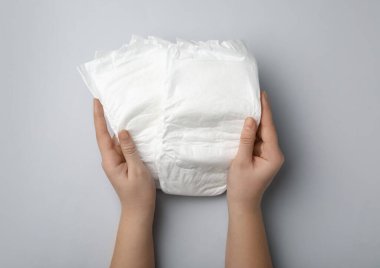 Açık gri arka planda bezi olan kadın, yakın plan.
