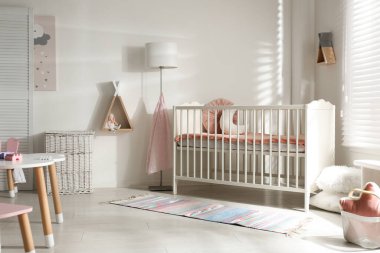 Beşik ve dekorasyon elementleriyle şirin bir bebek odası.