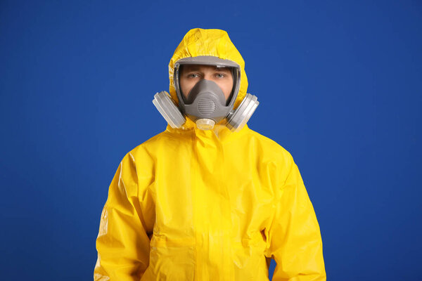 Man wearing chemical protective suit on blue background. Virus research
