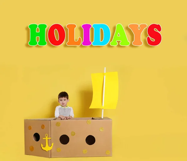 School Holidays Cute Little Child Playing Cardboard Ship Yellow Wall — Stock Photo, Image