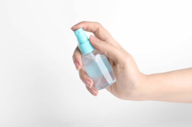 Beyaz arka planda antiseptik sprey tutan kadın, yakın plan.