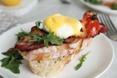 Benedict yumurtası tabakta servis ediliyor, yakından.