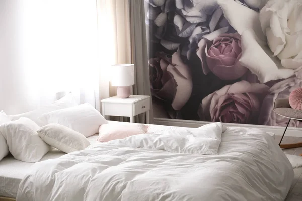 花の壁紙と壁の近くの快適なベッド スタイリッシュな部屋のインテリア — ストック写真
