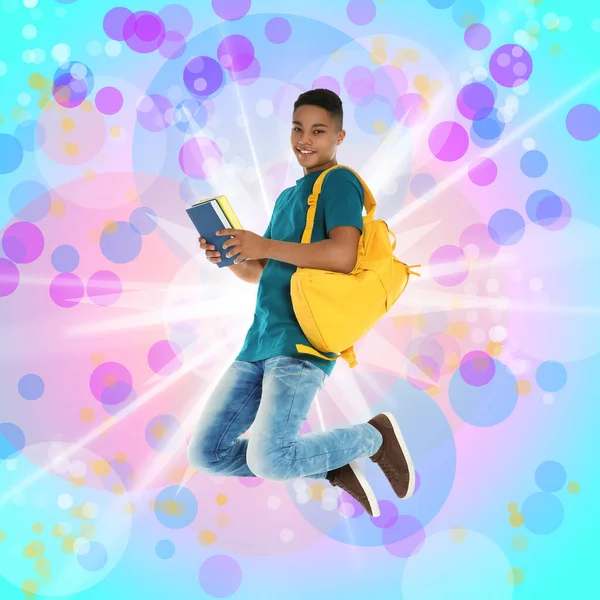 アフリカ系アメリカ人の10代の少年がカラフルな背景でジャンプします 学校の休日 — ストック写真