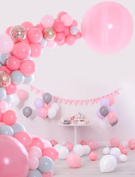 Baby shower party for girl. Different treats in room decorated with balloons