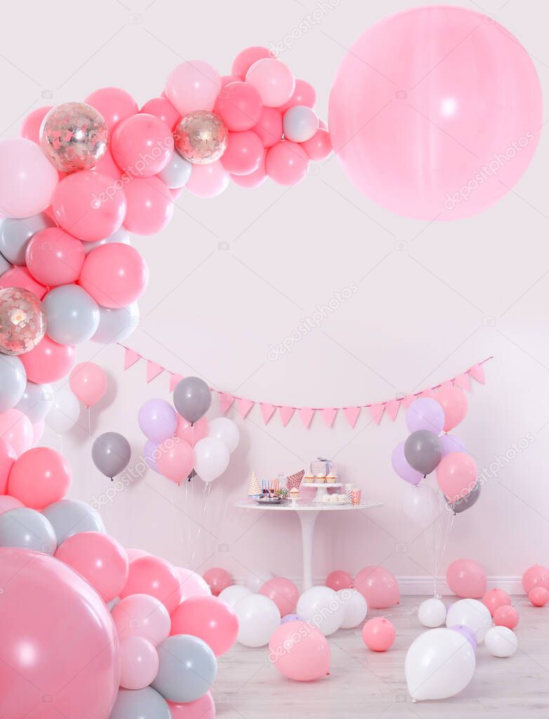 Baby shower party for girl. Different treats in room decorated with balloons