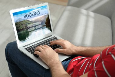 Geziyi planlamak için dizüstü bilgisayar kullanan adam, yakın plan. Seyahat acentesi web sitesi
