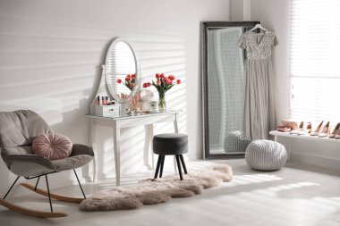 Zarif makyaj masası ve aynası olan şık bir oda.